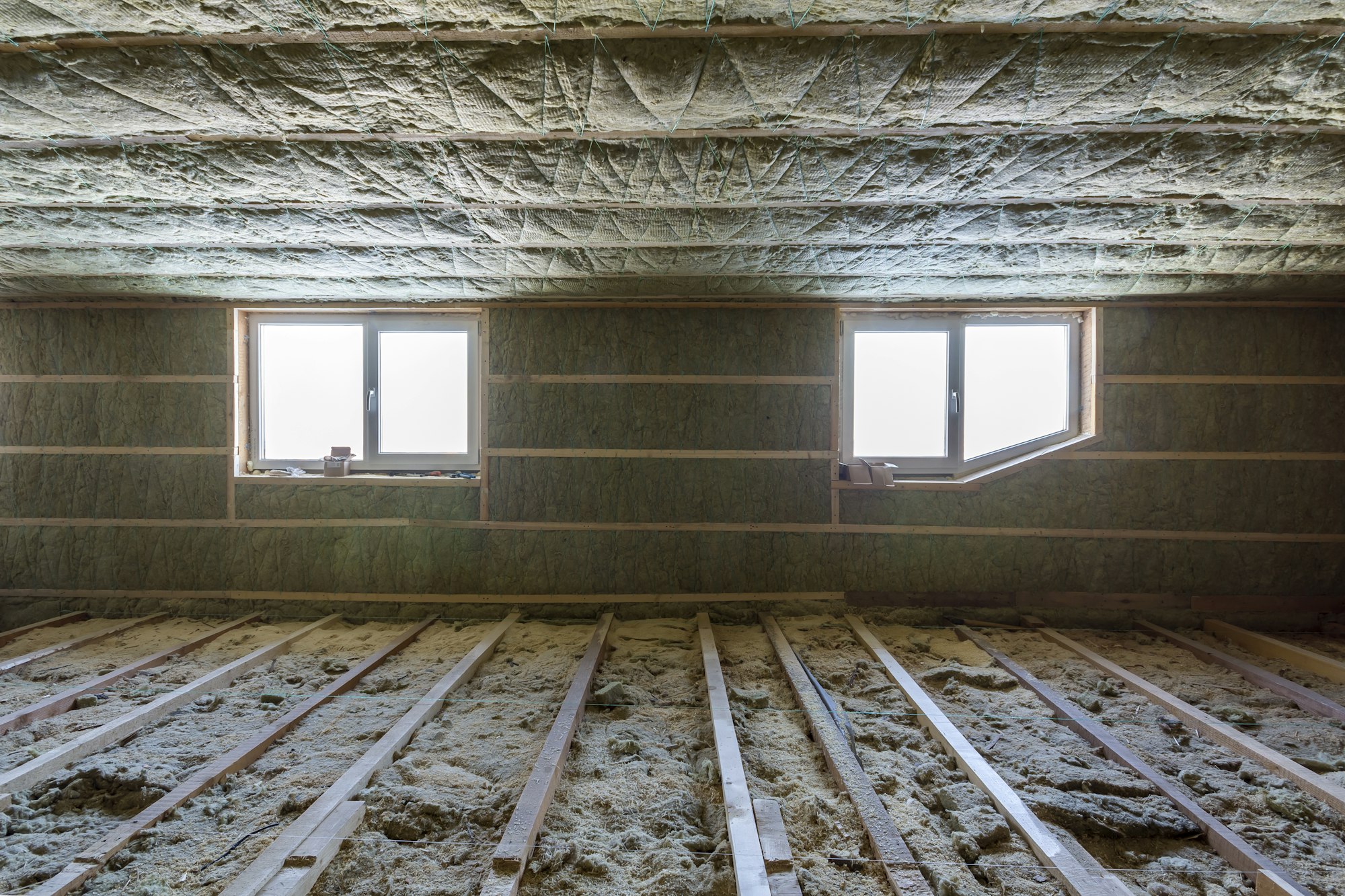 House attic under construction. Mansard walls and ceiling insulation with rock wool. Fiberglass