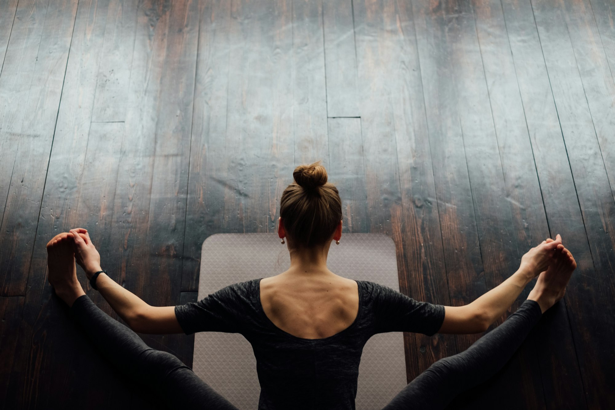 Top view of sport woman stretching on the floor